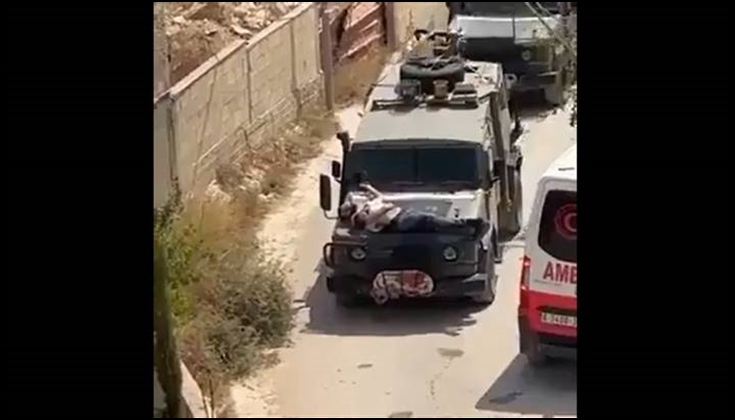 الاحتلال يقيّد جريحاً فلسطينياً بمقدمة عربة عسكرية كدرع بشرية